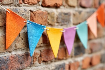 Colorful paper pennant flags brighten up the brick wall at a festive gathering location