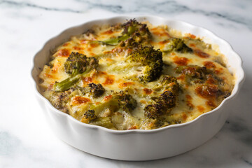 Casserole Cauliflower and broccoli baked with cheese sauce in a pot close-up on a wooden table. Horizontal top view from above. Broccoli gratin.