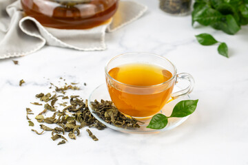 Cup of healthy green tea with tea leaves.