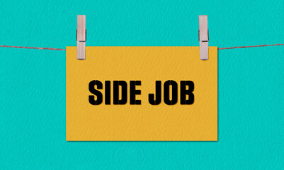 SIDE JOB Symbol. Concept words SIDE JOB on Yellow Rectangle Paper Hanging on a Wooden Clothespin...