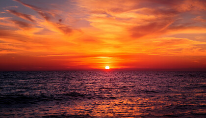 fiery sunset over the horizon a vibrant and captivating sunset paints the sky with fiery hues casting an orange glow on the tranquil water below creating a mesmerizing natural spectacle