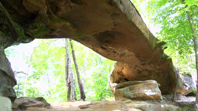 Establishing tilt shot of natural bridge formation in woods 4k
