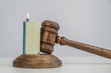 Judge's gavel and e-cigarette. Smoking ban. Tobacco heating systems. 