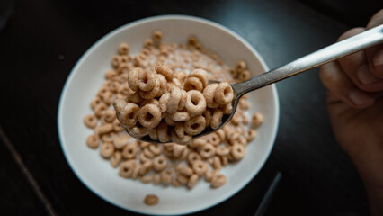 Healthy Whole Grain Cereal Rings with Milk on a Spoon