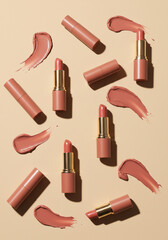 Obraz premium Batons e Brilhos Labiais Nude em Composição Flat Lay