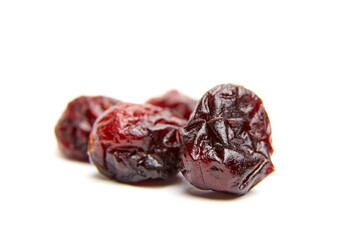 Dried cranberries arranged on a white background, showcasing their rich color and wrinkled texture, highlighting the natural sweetness and health benefits of this popular snack