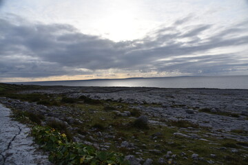 stone field near the sea with green fields