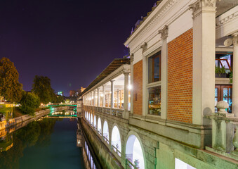 Ljubljanica riverfront at night with reflections and glowing lights