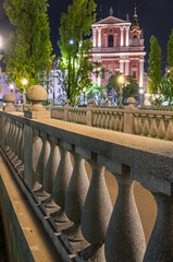 Triple Bridge and Franciscan Church illuminated at night in Ljubljana