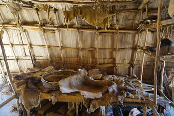 Traditional Native American hunting trophies: Deer hide, furs, and skins on display on a table inside an authentic tribal tent