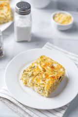 Cabbage cheese casserole in a plate on a white background