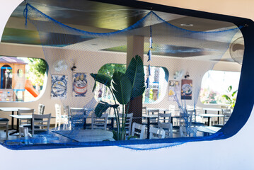 Coastal-themed restaurant interior with nautical decor and netting