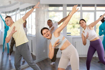 Dynamic young lady training hip-hop dance poses in dancehall during workout session