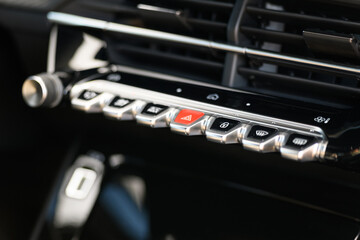 Close-up photo of the control panel with climate and hazard buttons on a modern car