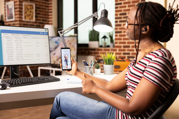 Female data analyst in virtual meeting with caucasian doctor, discussing updates to hospital...