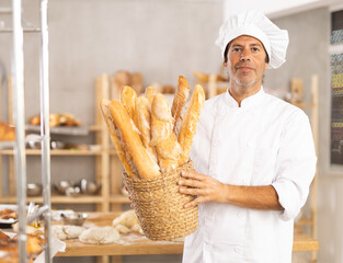 Bakery advertising banner. Caucasian male employee works in bakery kitchen, he demonstrate finished...