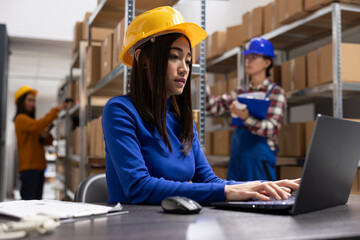 Asian female worker ensures shipping logistics in a small scale depot. Preparing taped boxes at the...