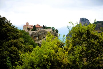 Obraz premium Varlaam Monastery perched on towering sandstone cliffs in Meteora, Greece. Historic Eastern Orthodox monastery.