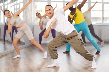 During dance workshop, European guy with team of like-minded multinational people learn to perform...