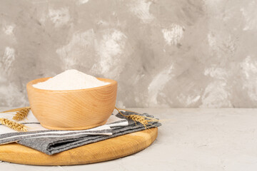 Bowl with spelt flour on concrete background