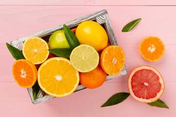 Different citrus fruits on wooden background, top view