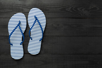 Striped blue flip flops on wooden background, top view