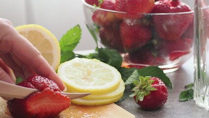 woman making refreshing homemade lemonade detox drink or cocktail summer with ice. Refreshing...