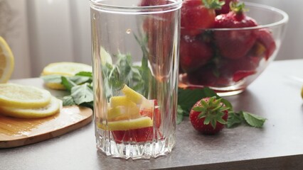 woman making refreshing homemade lemonade detox drink or cocktail summer with ice. Refreshing...