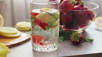 woman making refreshing homemade lemonade detox drink or cocktail summer with ice. Refreshing...