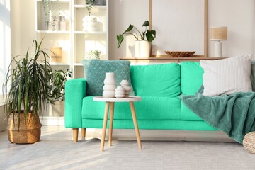 Interior of living room with green sofa, table and shelving unit