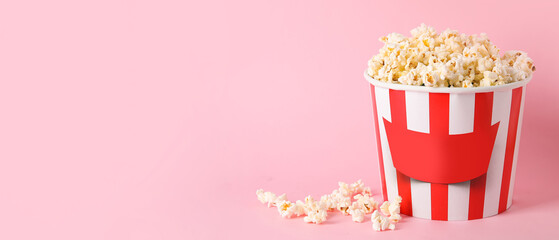 Bucket with tasty popcorn on pink background