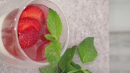 Vanilla panna cotta with strawberry layer in a small portioned vase and fruit pieces in wineglasses. Delicious Italian dessert. low calorie dessert healthy eating diet. woman cooking at home