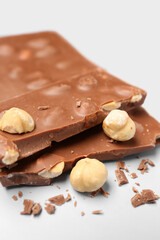 Sweet tasty chocolate with nuts on  light background, closeup