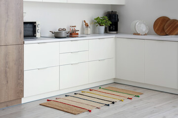 Interior of light kitchen with counters and carpet