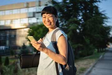 mature japanese woman sportswoman athlete use mobile phone outdoor