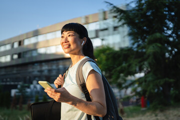 mature japanese woman sportswoman athlete use mobile phone outdoor