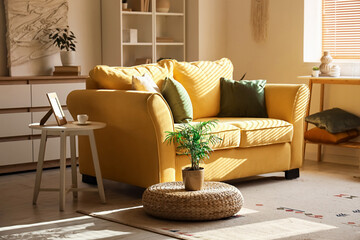 Interior of stylish room with comfortable yellow sofa and houseplants
