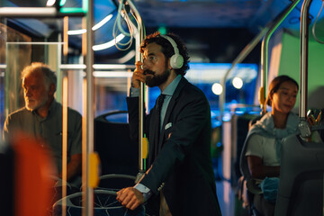 Businessman listening to music on headphones while riding bus