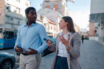 Business colleagues walking and talking on city street