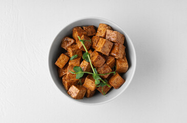 Bowl with pieces of fried tofu cheese and micro green on white background