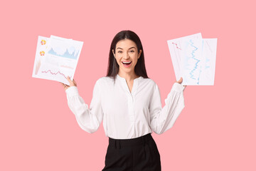 Young businesswoman with diagrams on pink background