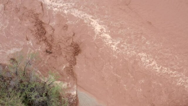 Aerial footage crossing over a road flooded by an Arizona monsoon flash flood in a formally dry wash. . 