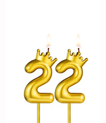 Golden number 22 birthday candle on white background