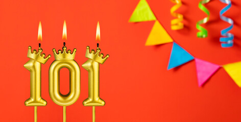 Number 101 candle - Birthday celebration on an orange background with pennants