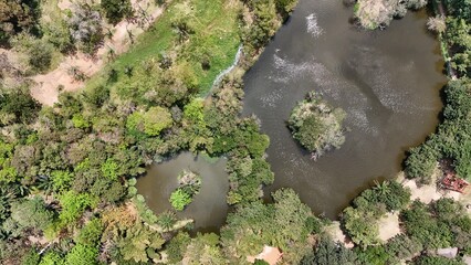 Lush aerial view of interconnected ponds amidst dense green foliage of Achimota Forest, Ghana....