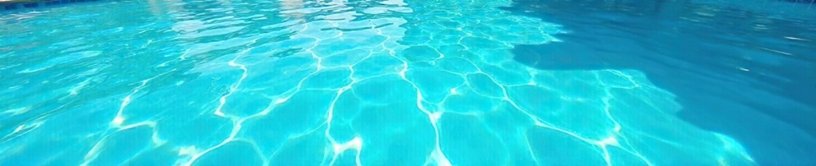 Fototapeta premium Sparkling Turquoise Pool Water Shimmers Under Summer Sun, Reflecting a Clear Sky; Perfect for Vacation, Travel, or Summer-Themed Designs. Inviting, Refreshing, and Calming.