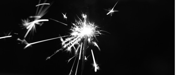 Black and white of ignites handheld firework sparkler as background