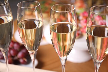 Buffet menu. Glasses of sparkling wine and tasty appetizers on table, closeup
