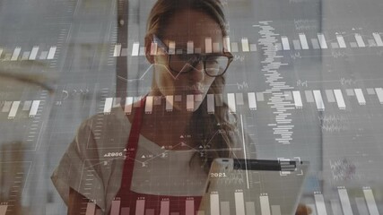 Adult woman holding tablet scrolling reviewing shop metrics with animated charts floating in cafe - Powered by Adobe