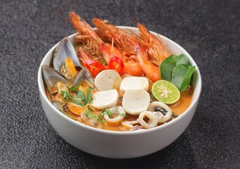 Traditional Thai soup Tom Yum kung with seafood, fish ball,coconut milk and chili pepper